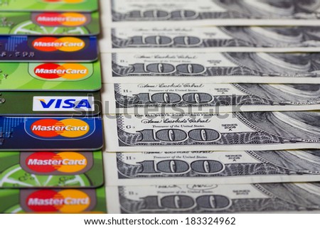 KIEV, UKRAINE - March 22: Pile of credit cards, Visa and MasterCard, with US dollar bills, in Kiev, Ukraine, on March 22, 2014.
