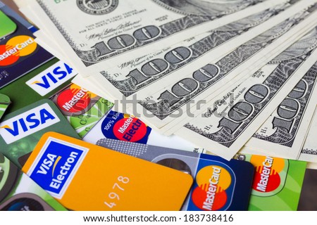 KIEV, UKRAINE - March 22: Pile of credit cards, Visa and MasterCard, credit, debit and electronic with US dollar bills, in Kiev, Ukraine, on March 22, 2014.