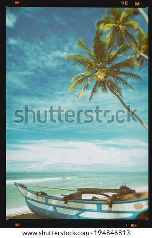 Small wooden fishing boat under palm tree on tropical beach, retro film stylized and toned