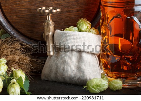 Beer barrel with hops, wheat and beer glass close-up