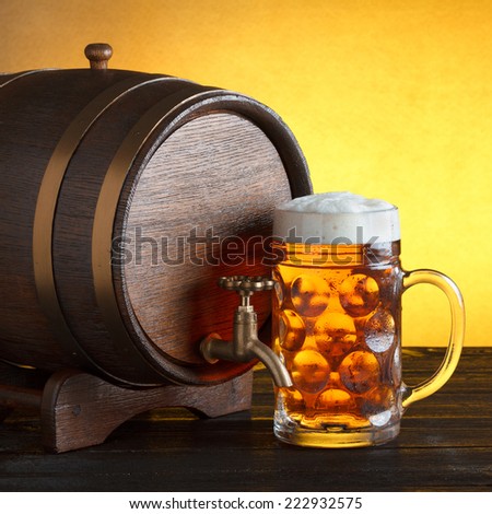 Vintage beer barrel with huge beer glass on wooden table still life, copy space