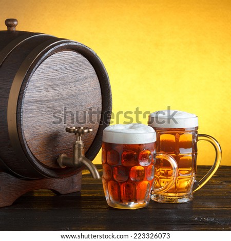 Vintage beer barrel with two beer glasses on wooden table still life