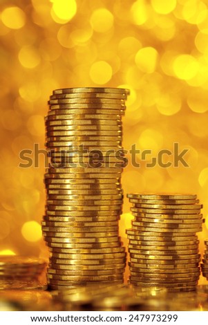 Golden coins on bright golden bokeh background