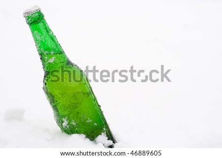 beer bottle in snow with copyspace (no isolation)