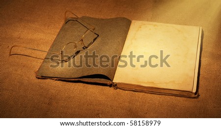 old book and glasses in ambient light