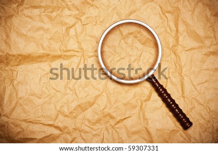 magnifying glass on old yellow paper