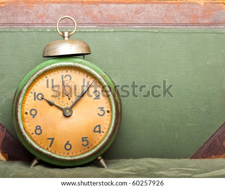 vintage clock with old book on background