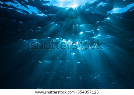 Underwater shot with sun rays in deep blue tropical sea