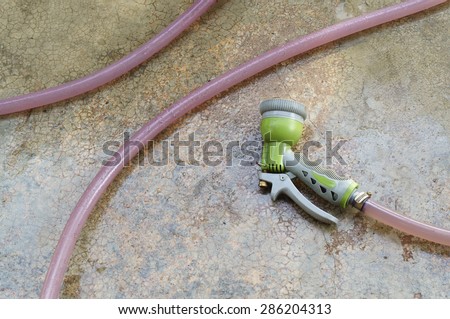 old water spray hun and hose that put on cement ground