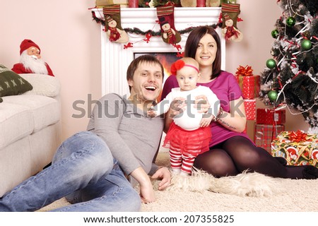 happy Christmas family near the pine and fireplace