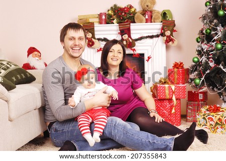 happy Christmas family near the pine and fireplace