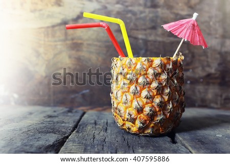 pineapple with straw and cocktail umbrella