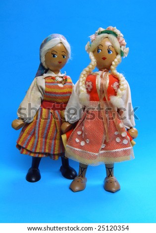 Pair of antique Polish girl dolls on blue background