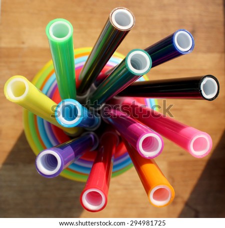 colored felt-tip pens in plastic cups