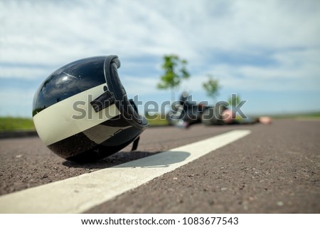 biker helmet lies on street near a motorcycle accident