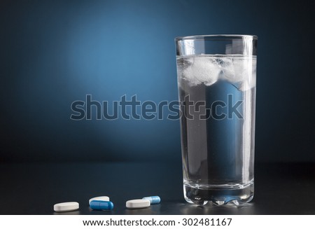 Medicine pills and glass of drink water
