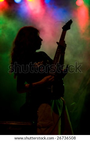 Hard Rock male Heavy Metal Guitarist playing black electric guitar in live music gig concert