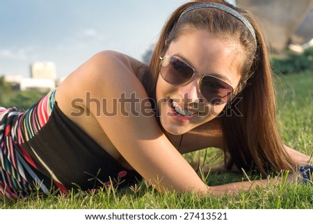 portrait of beautiful young female woman Cute girl Fashion Teen Model Smiling Laughing in Sunny Outdoors with sunglasses green grass glasses