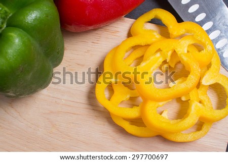 The yellow sweet pepper cut on a wooden cutting board.