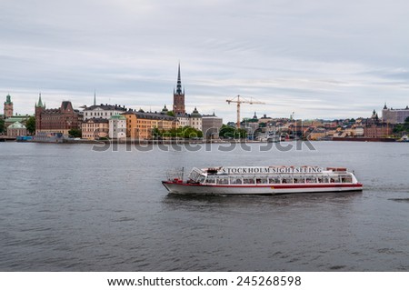 STOCKHOLM, SWEDEN - JULY 28: Tourists on the sightseeing boat watching the sights of Stockholm in cloudy weather. Classical skyline can be seen in the background at July 28, 2010 in Stockholm, Sweden.