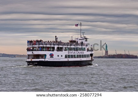 NEW YORK CITY, USA - NOVEMBER 15: The Statue Cruises boat with tourists sails to the Statue of Liberty in nasty weather with the Statue of Liberty in the background at November 15, 2011.