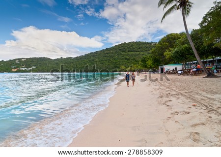 MAGENS BAY, ST. THOMAS, U.S. VIRGIN ISLANDS - DECEMBER 5: Two people walk along the beach in Magens Bay, St. Thomas, U.S.V.I. at December 5, 2011.