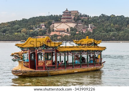 BEIJING, CHINA - OCTOBER 14, 2013: Tourists on a dragon boat floating on the Kunming Lake, Beijing, China. Summer Palace in the background..