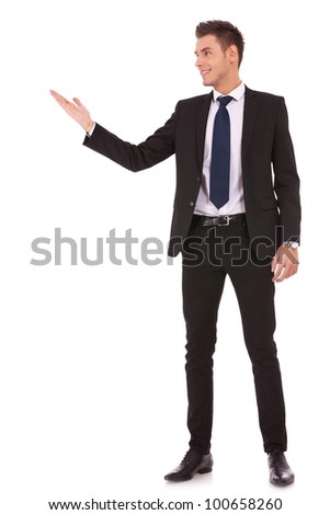 Attractive business man shows you copy space on white background