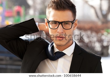 portrait of a young business man with a flying tie - outdoor picture