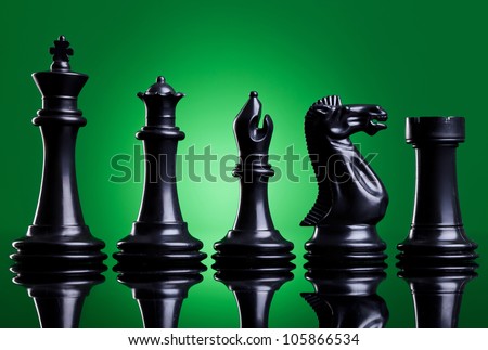 Black chess pieces in order of decreasing importance, on green background