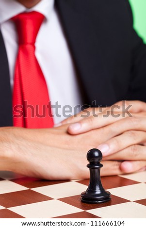 Businessman behind his only pawn on the chessboard