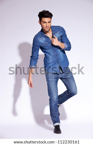 Full Body Of A Fashion Man Holding His Jeans Shirt By Its Collar