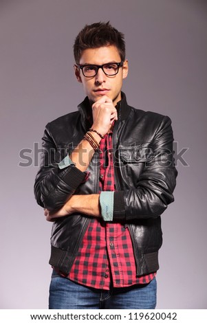 portrait of a pensive young man with leather jacket and glasses