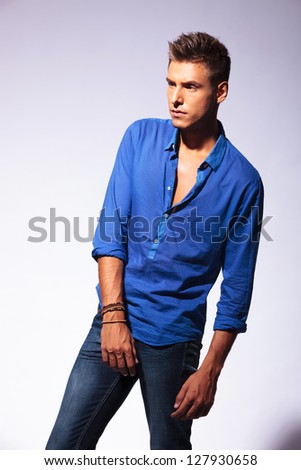 cutout picture of a young casual man posing in a crooked position and looking away from the camera, on light background