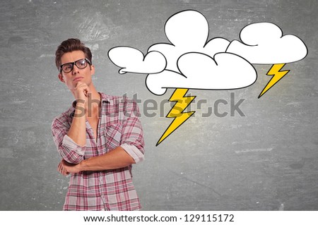 young casual man with glasses facing a big problem and thinking for a solution
