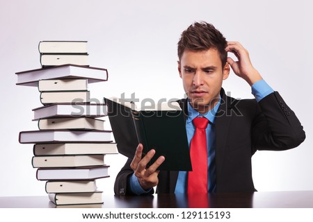 young business man confused of what he is reading at his desk