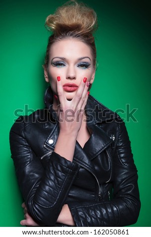 portrait of a young sexy woman holding her chin, dressed casual in leather jacket