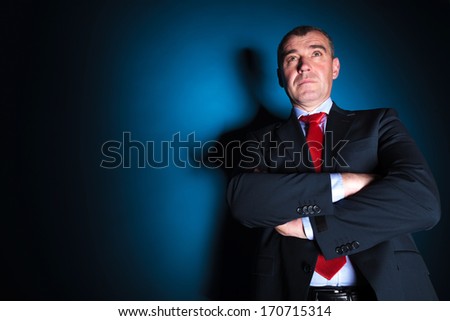 serious old business man with arms folded looking away from the camera