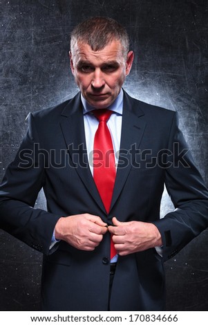 dramatic picture of a serious old business man unbuttoning his suit