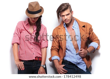 casual young woman looking down while her boyfriend looks to the camera and poses