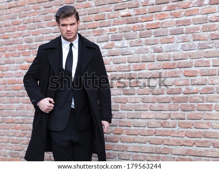 young business man posing outdoor with a strong expression while looking into the camera
