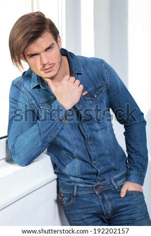 young sexy man in casual jeans clothes is thinking and looks at the camera