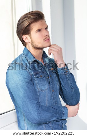 side view of a thoughtful young man in casual jeans clothes