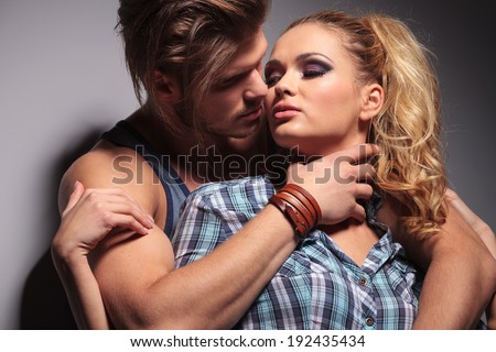sexy muscular man embracing his girlfriend in studio
