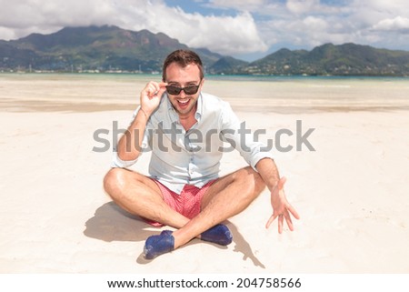 this is the life i want to live forever! seated man on the beach bursting with joy
