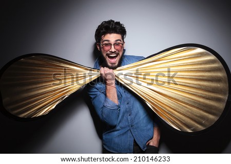 fashion man having fun with a big bow tie at his neck, screaming of joy