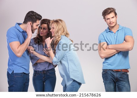 group of people making fun and gossip about their friend on grey studio background