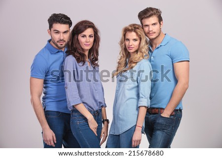 happy group of young casual people looking at the camera on grey studio background