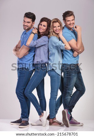 happy young casual group of people standing together and smile on grey studio background