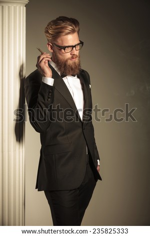 Side view of a elegant business man looking away from the camera while holding a cigarette in his hand.